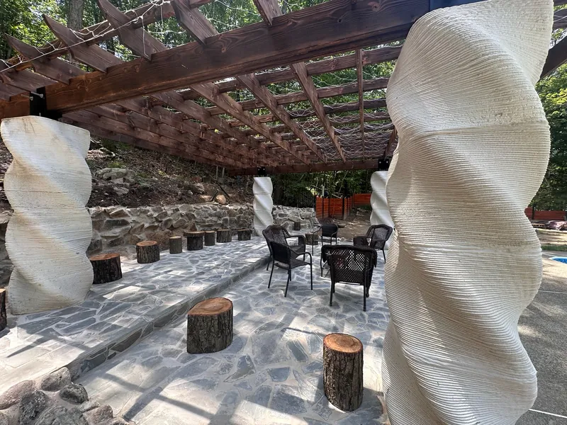Helical twisted concrete columns supporting a timber pergola.